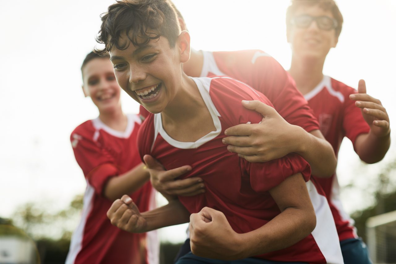 Unge fotballspillere feirer etter mål