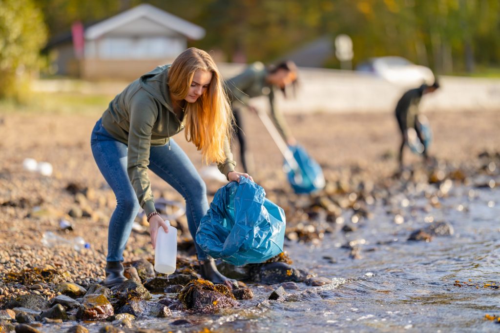 Ungdommer plukker søppel på en strand
