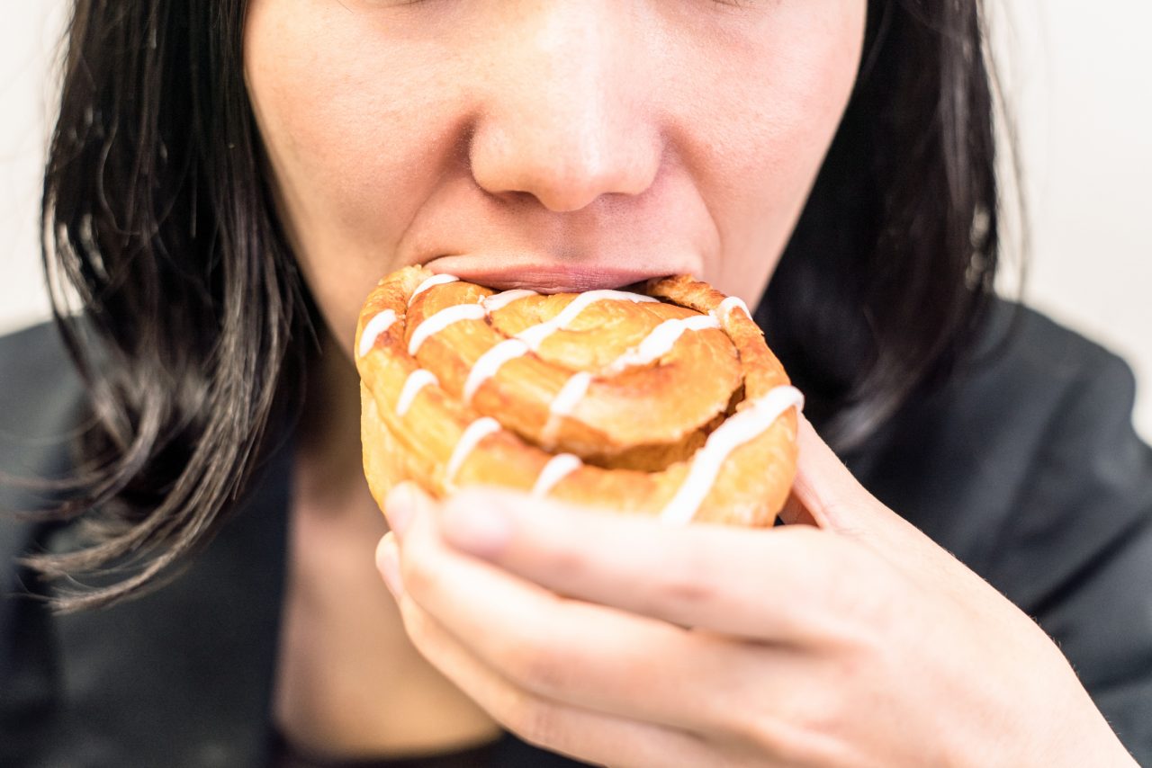 Forretningskvinne spiser en kanelsnurr