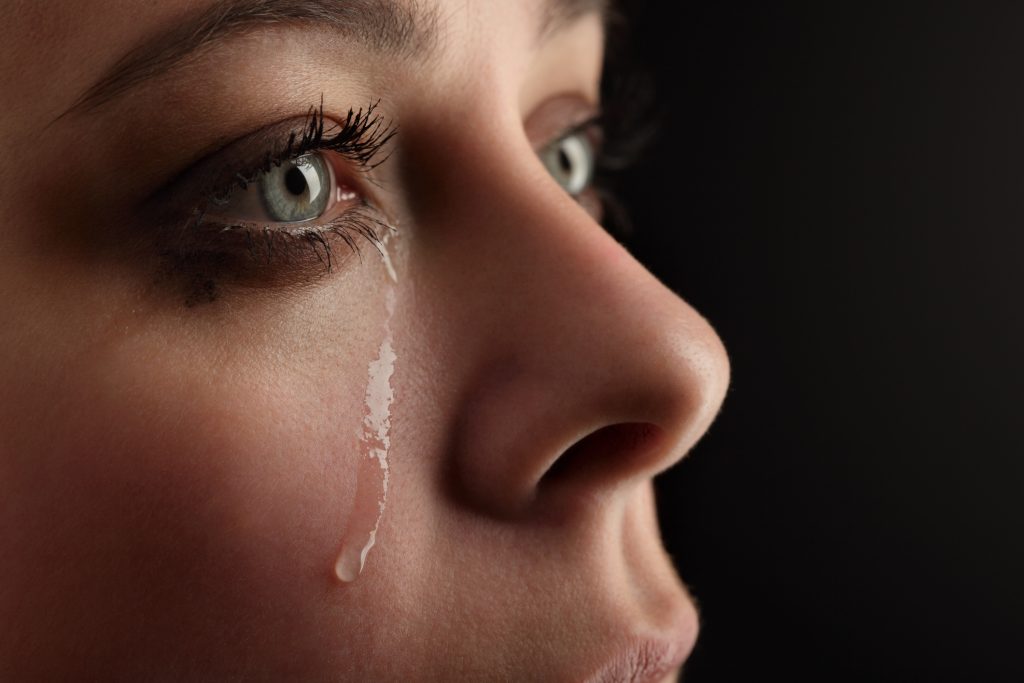 Nærbilde av en kvinne med en tåre som renner ned ansiktet