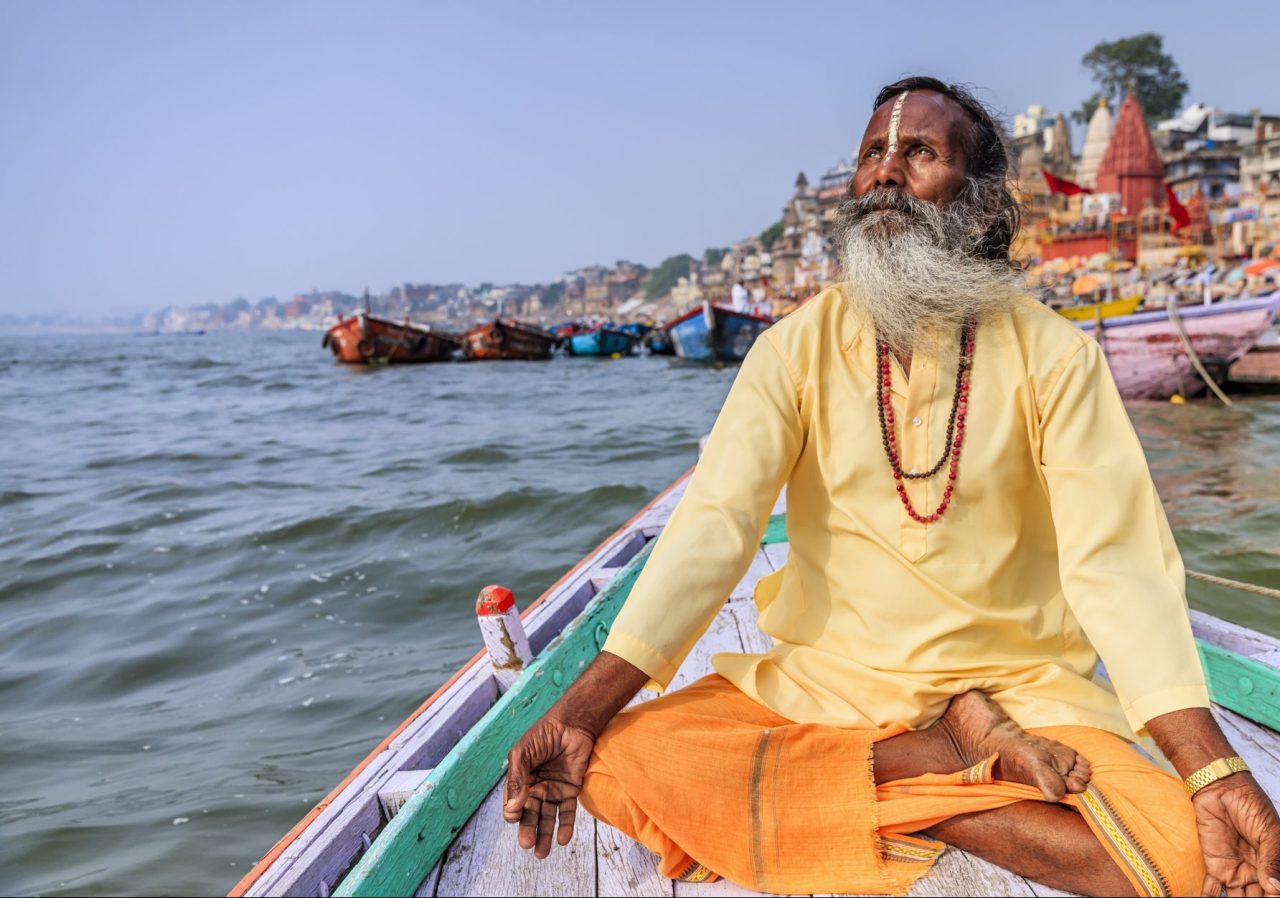 Munk mediterer på en båt i Ganges, India