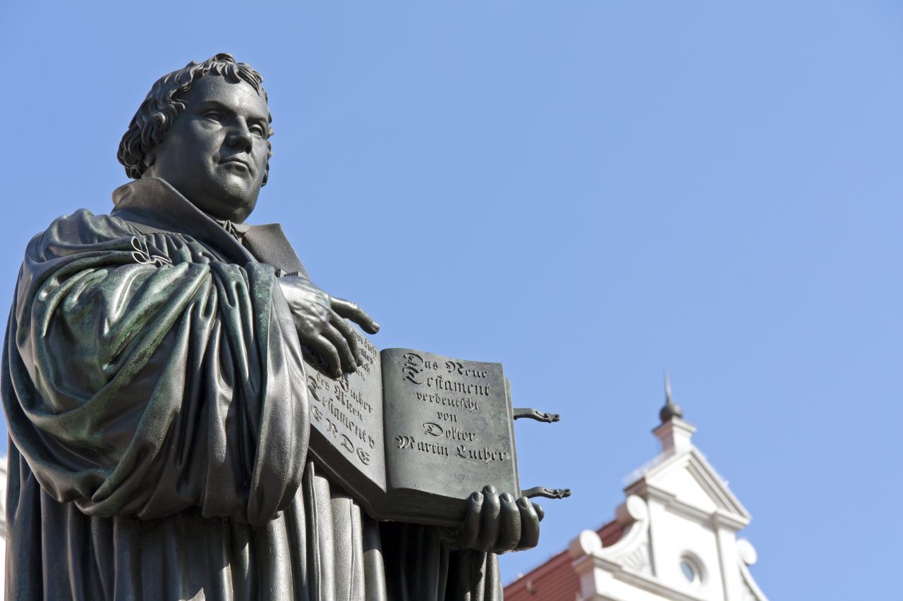En statue av Martin Luther som peker på en bok