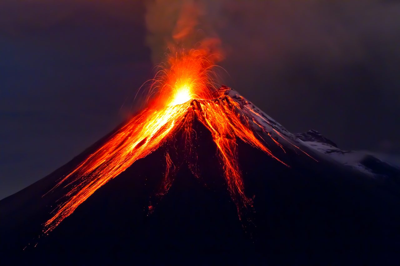 Oransje og rødt vulkanutbrudd midt på natten.