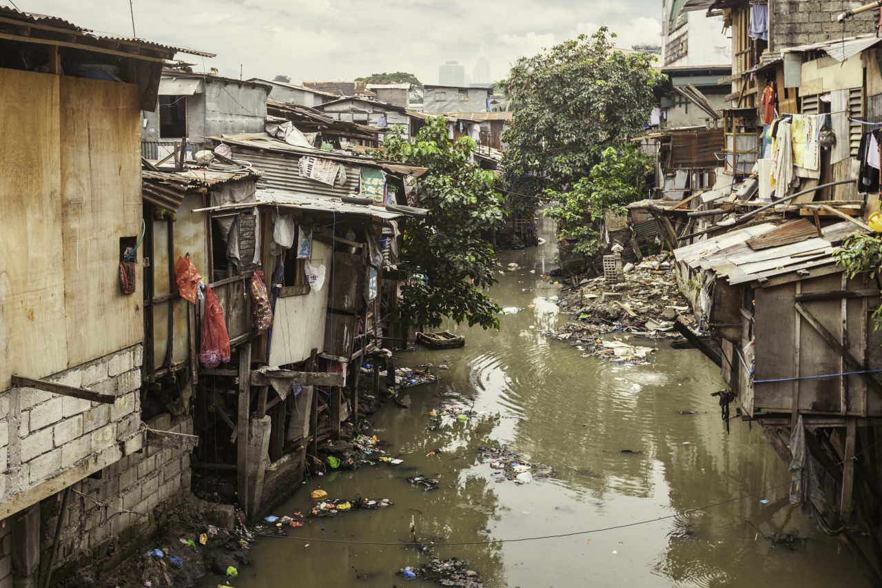 En forurenset elv som renner gjennom et slumområde på Filippinene.