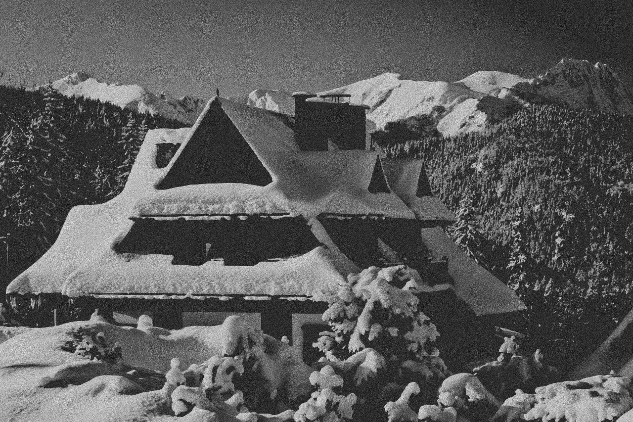 Stor, snødekt hytte på fjellet