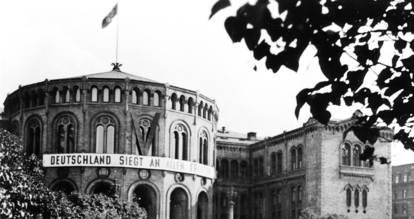 Stortinget i Oslo i 1940 med hakekorsflagg og stort banner med tysk tekst.