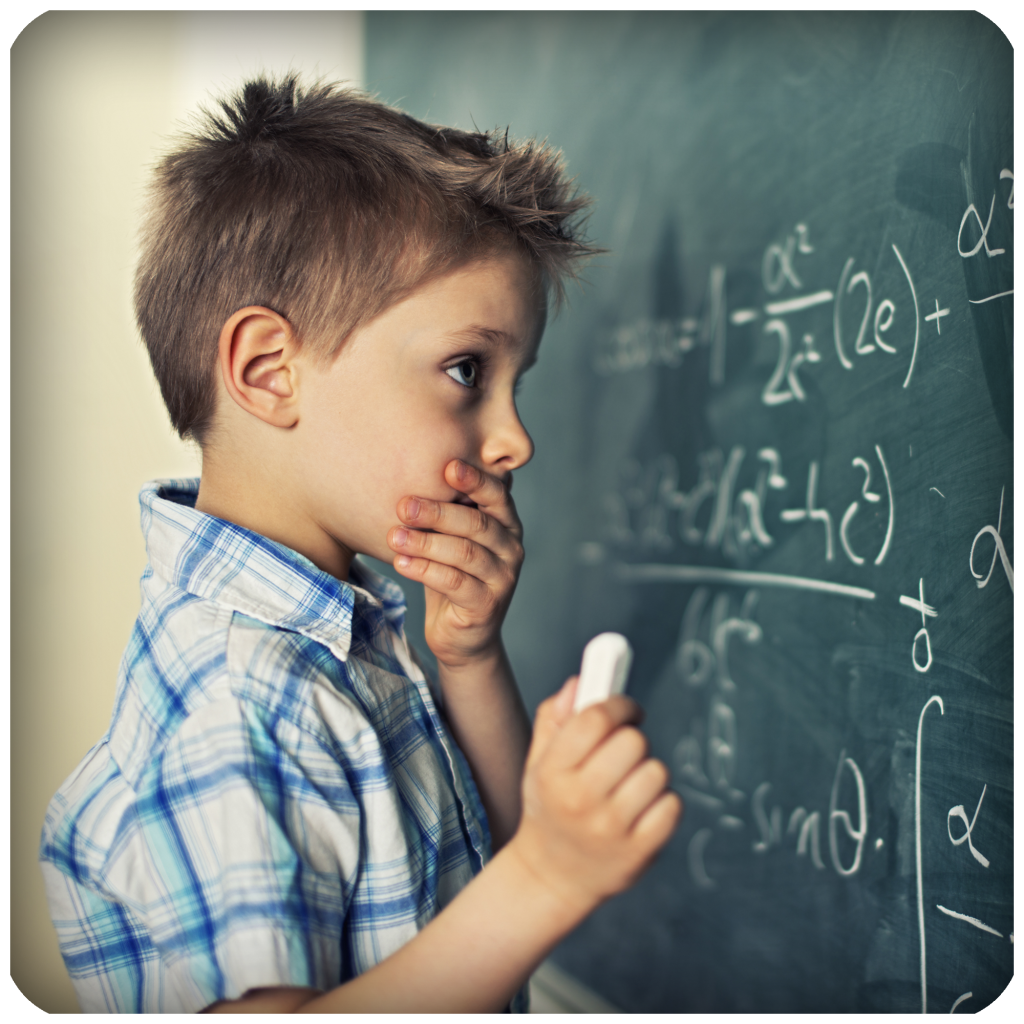 Ung gutt løser regnestykke på tavla