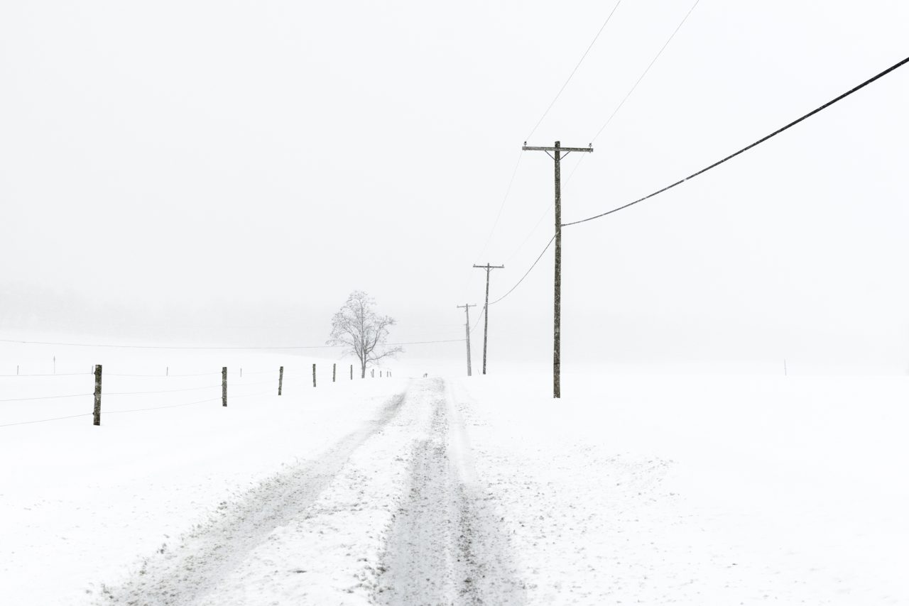 En øde veistrekning i et snødekt landskap