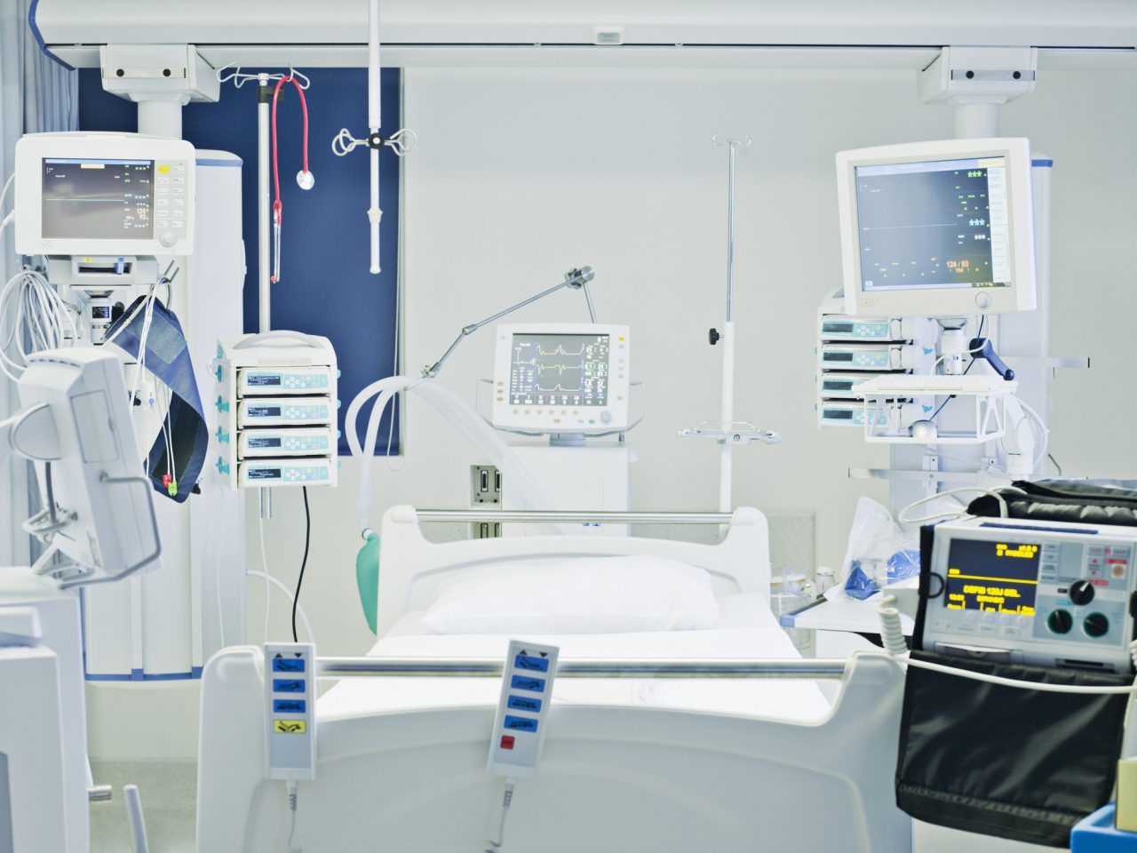 Tom sykehusseng omringet av medisinsk og teknologisk utstyr
