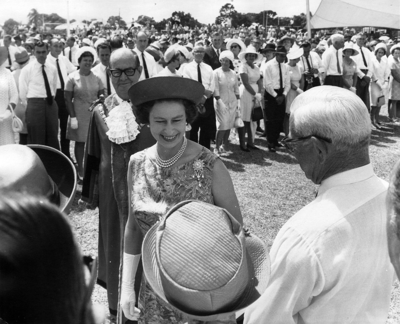 Sort/hvitt bilde av Dronning Elizabeth II hilser på folket på en av sine reiser