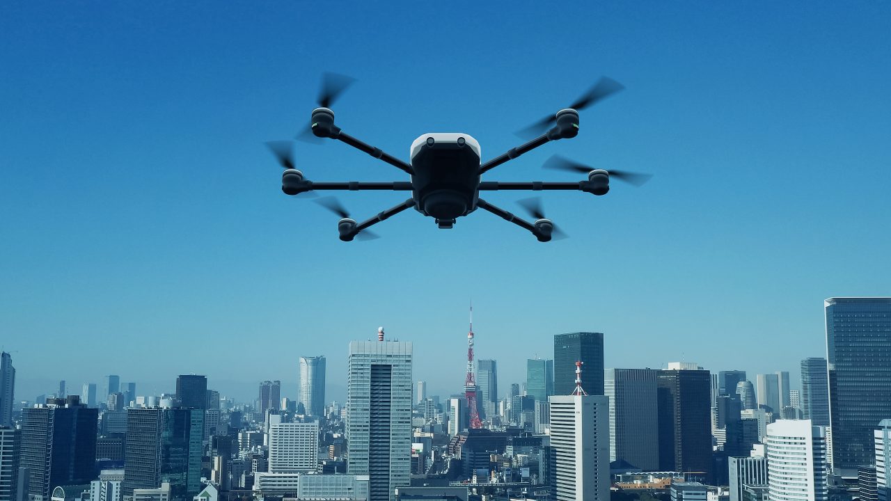 En drone som flyr inn mot en by