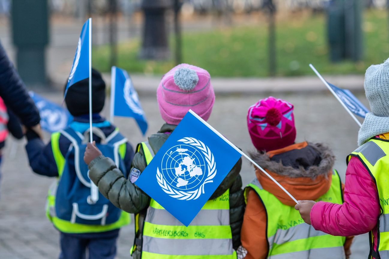 Barnehagebarn som vifter med FN-flagg
