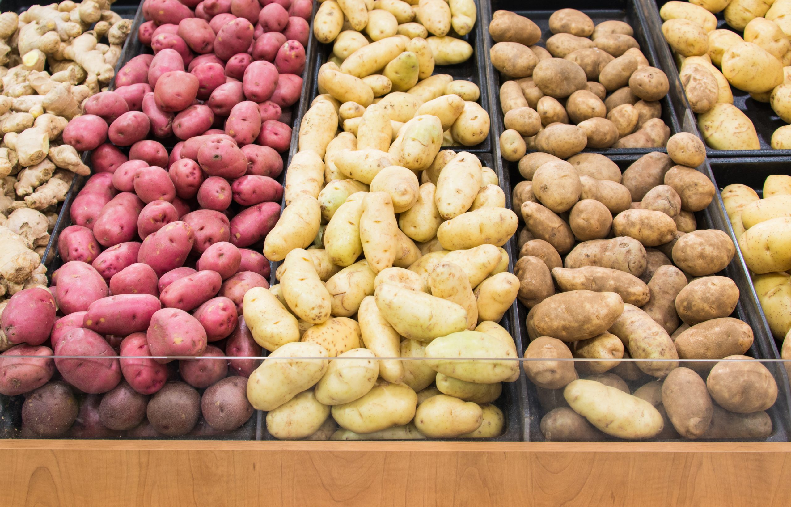 Flere typer poteter som ligger i kasser i en dagligvarebutikk