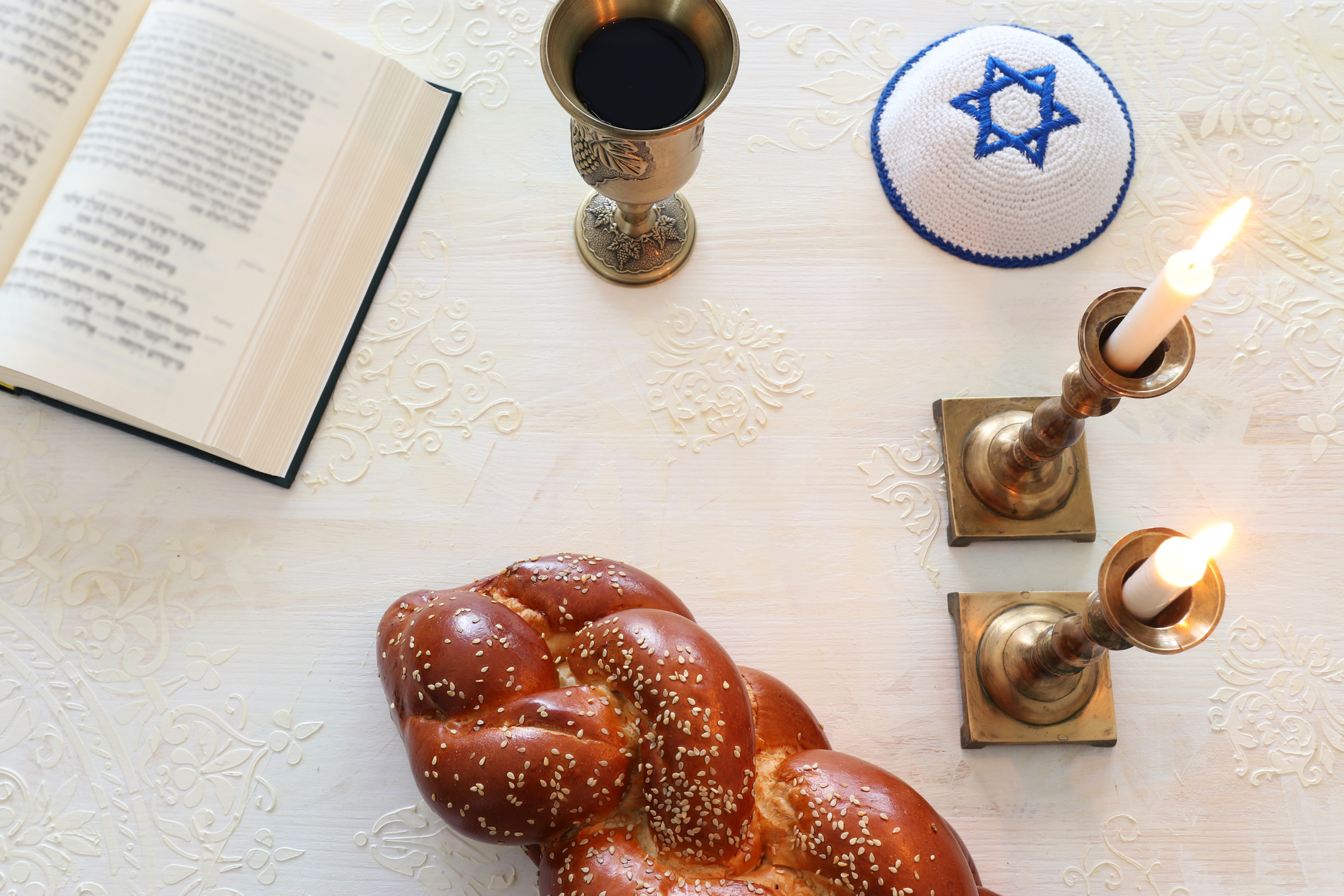 Et jødisk måltid med mat, toraen, vin, lys og en kipa med davidsstjernen på. Symboliserer sabbaten.