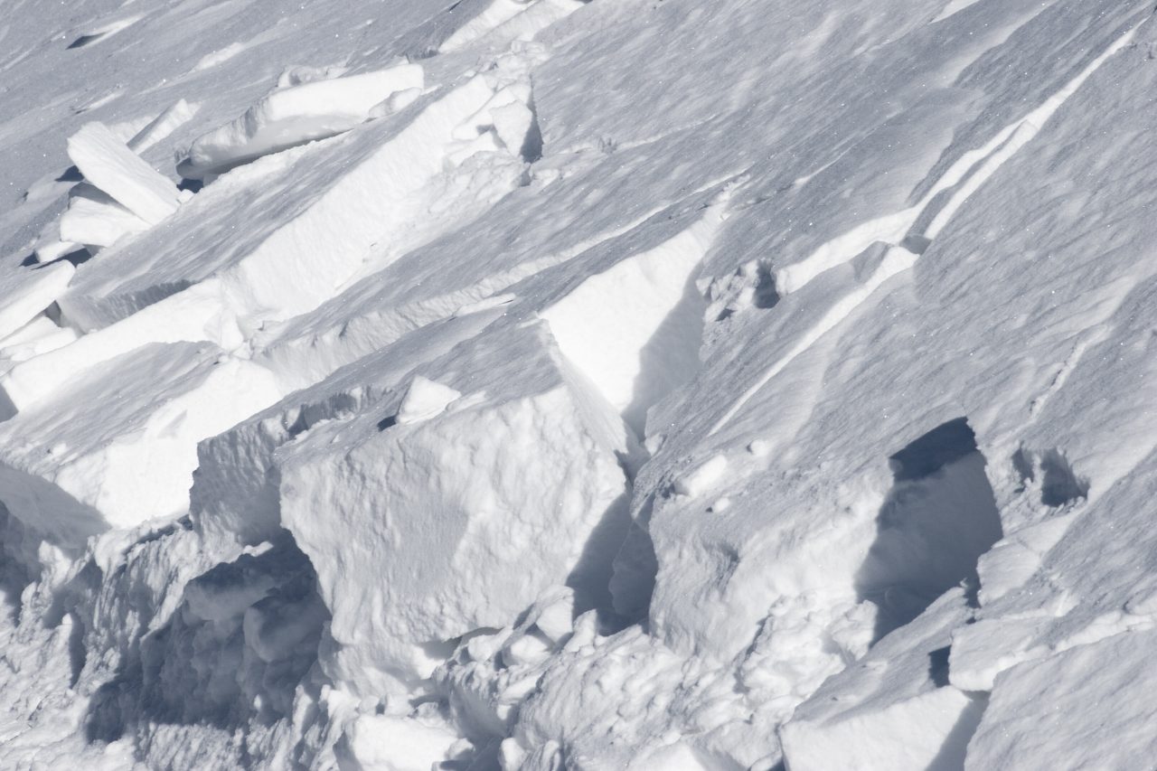 Sprukket hvit snøoverflatebakgrunn i vinterens sollys