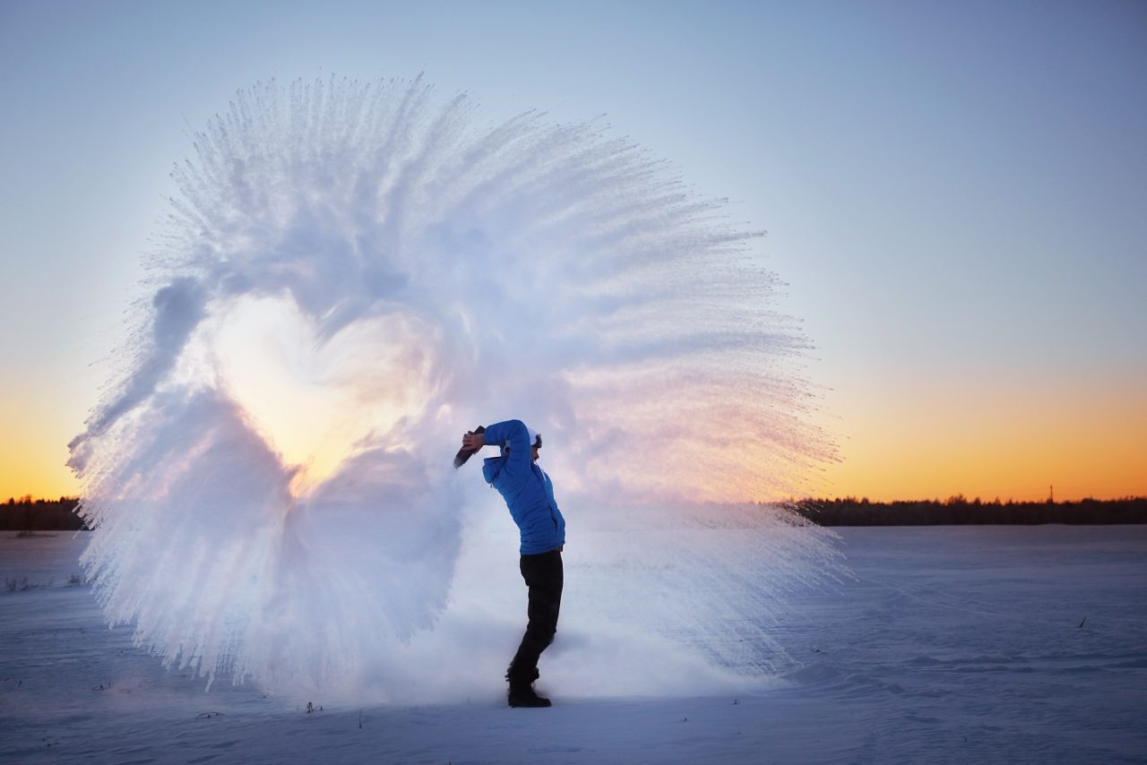En person som kaster vann opp i luften en kald vinterdag, slik at vannet frosser i luften. Det dannes en sirkel i luften av isvannet og et hjertet i midten.
