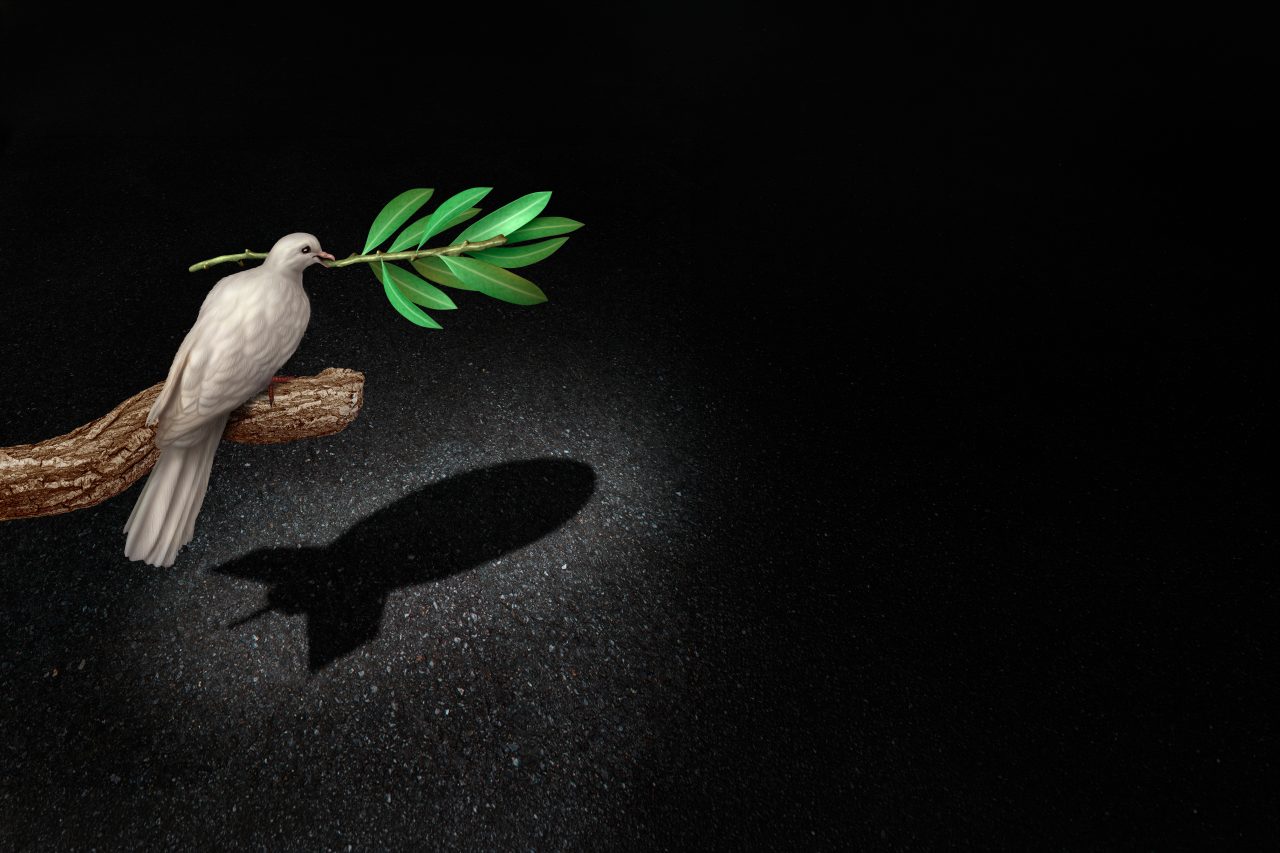 En fredsdue som symboliserer frihet, med en olivengren i nebbet, kaster en skygge formet som en bombe