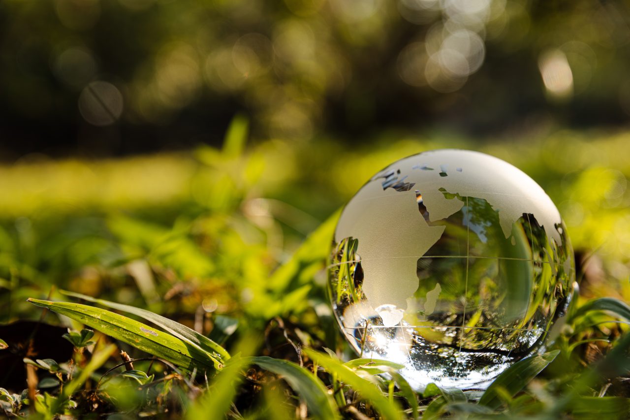 En krystallkule ligger på et teppe av grønt gress