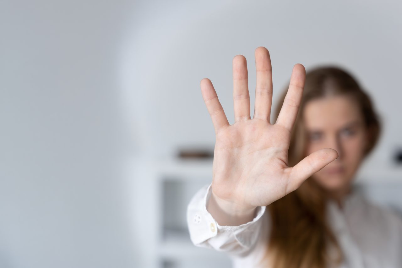 Kvinne som lager et stoppskilt med hånden