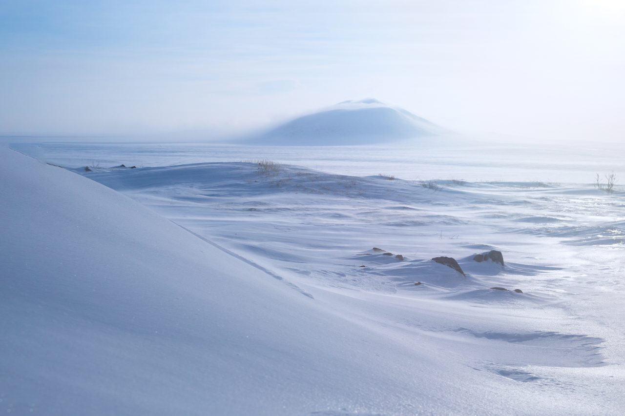 Et arktisk vinterlandskap med snødekt tundra og åser